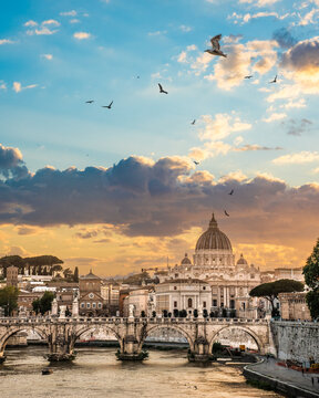 Beautiful illuminated view of Rome, Italy with Saint Peters Basiica, historic architecture, bridges and Tiber River under evening sky. 