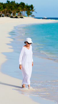 Person Walking on Tropical Beach in White Linen Outfit with Sunglasses and Clear Water