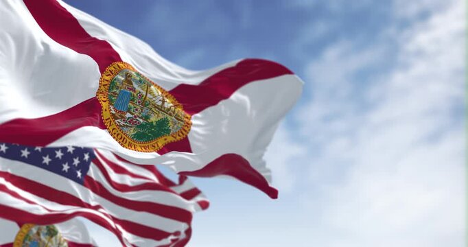 Flags of Florida and United States waving in the wind on a clear day