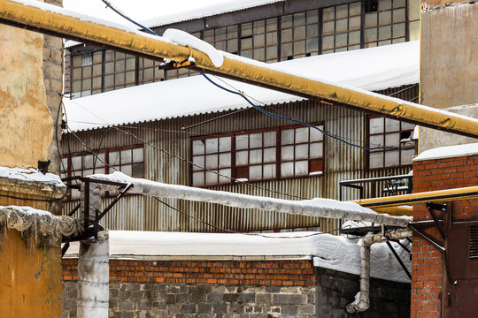 snow-covered pipelines in factory yard in winter