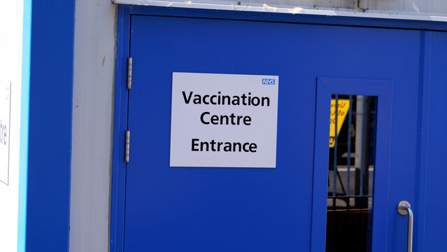 Leicester, England, UK - 6 July 2026: Vaccination centre entrance, blue door with NHS vaccine clinic sign, healthcare facility exterior, medical public health service point