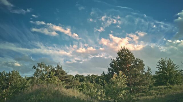 Beautiful dramatic clouds timelapse evening sky forest edge.Ukraine. Fast moving colorful cumulus clouds sunset golden hour. Majestic nature scenery, cinematic countryside background, weather changing