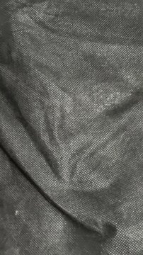 Black Non Woven Fabric Texture with Micro Dotted Pattern and Creased Surface Background
