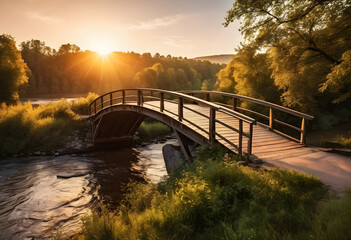Naklejka premium wooden hump bridge over river at golden hour
