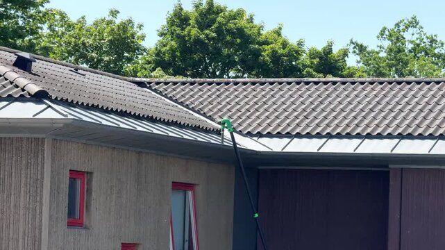 Roof gutter cleaning with vacuum maintenance on residential house