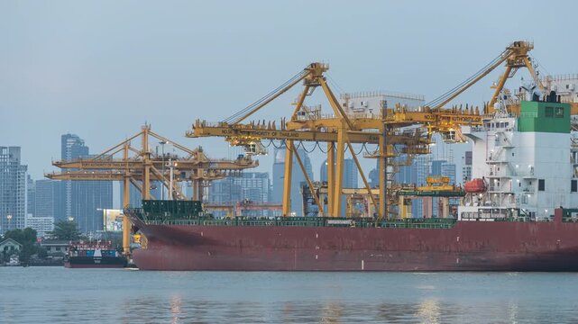 Time lapse of Container cargo ship at industrial port with cranes and city skyline at night. The scene of global logistics, maritime transportation, international trade, modern port infrastructure.