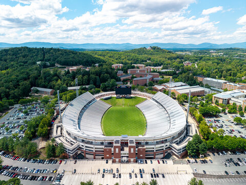 defaultCharlottesville, Virginia, impressive aerial drone view looking down over Scott Stadium at the University of Virginia, showcasing the green football field, stadium seating, and surrounding fore