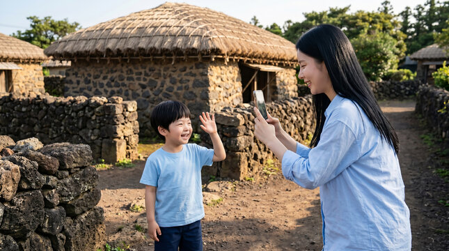 제주 돌담 앞에서 한라봉을 보여주는 모자 / Mother and Son Showing Hallabong Orange by Jeju Stone Wall
