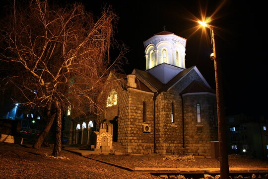 Stone Orthodox church illuminated at night with streetlight