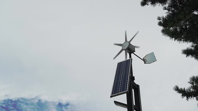 Solar panels and small wind turbines generating clean renewable or sustainable energy. Isolated by white cloudy skies. Full HD slow motion footage. Technology concept