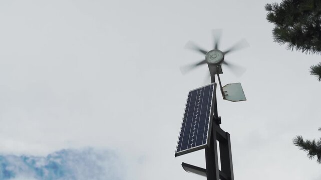 Solar panels and small wind turbines generating clean renewable or sustainable energy. Isolated by white cloudy skies. Full HD slow motion footage. Technology concept