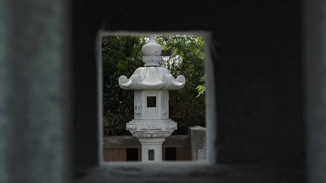 Japanese white stone lantern is a decorative garden ornament crafted from stone or marble. Full HD dolly movement, slow motion footage. Travel concept