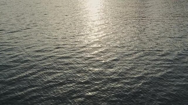 Beautiful sunset reflection shimmering on the calmly water surface. Full HD slow motion footage. Background water texture concept