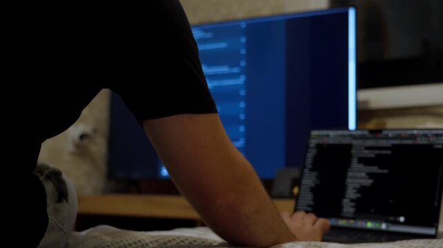 Programmer working with multiple screens in modern workspace