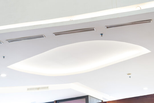 Modern office ceiling with recessed lighting and air vents