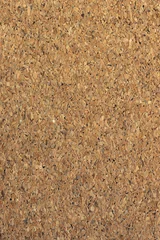 Vertical close-up of a natural brown cork board texture. Concept of office notice board, school bulletin, and blank background. © Win Nondakowit