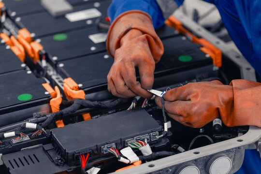 Professional EV Car Service, Male worker Electricity Vehicle Fix Maintenance EV Car Battery