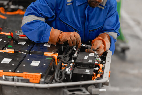 Professional EV Car Service, Male worker Electricity Vehicle Fix Maintenance EV Car Battery