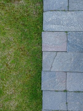 Stone stepping stones path on green grass lawn in garden background
