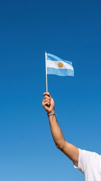 hand holding Argentina flag on nature background. 9th July of Independence day, 25th May of Revolution day and happy celebration concepts