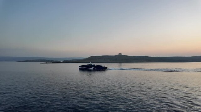 Comino, Malta 01.07.2026 - Comino during sunrise with a boat sailing around. Trip to Gozo, from Malta. High quality 4k footage