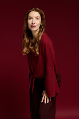 Fototapeta premium Elegant mature woman showcasing stylish fashion sense in a chic studio setting