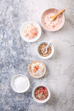 Assortment of gourmet salts in small bowls, including Himalayan and rose petal infused