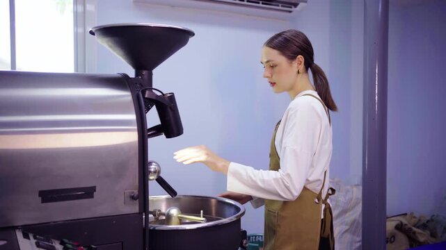Female roaster inspecting coffee roasting machine before use