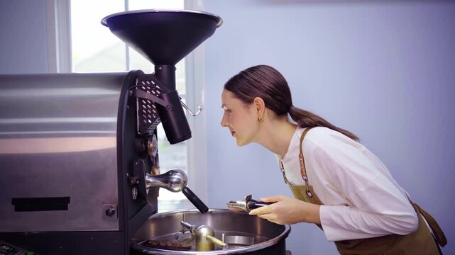 Female roaster inspecting coffee roasting machine before use