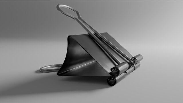 Black foldback clip office supply object with soft shadows on a clean backdrop