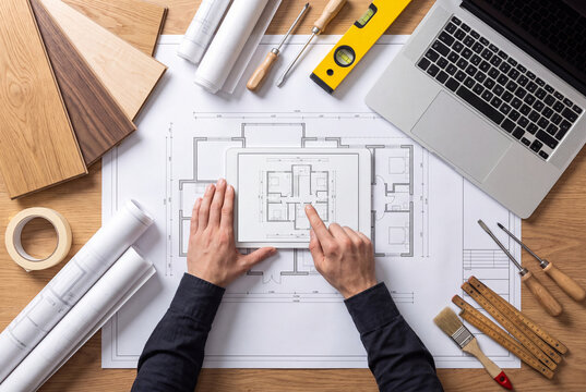 Architect Working on Blueprint with Office Planning Equipment