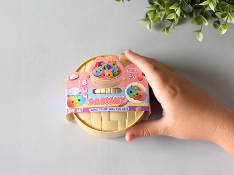 Hand holding colorful squishy toy package