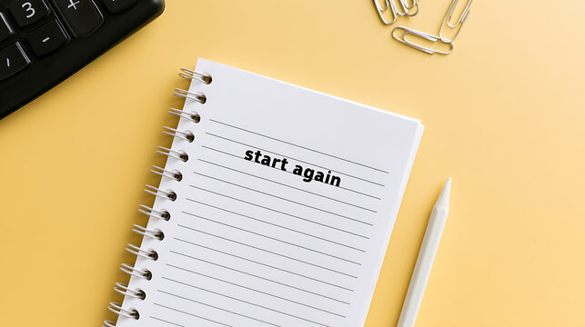 Inspiring Message 'Start Again' on Notebook with Pencil, Calculator, and Paperclips on Yellow Desk, Representing New Beginnings and Motivation
