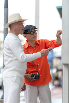 Senior LGBTQ couple checking a city transit map in Bangkok, Thailand