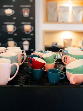 Colorful Cups Arranged on a Coffee Counter in a Cafe Setting