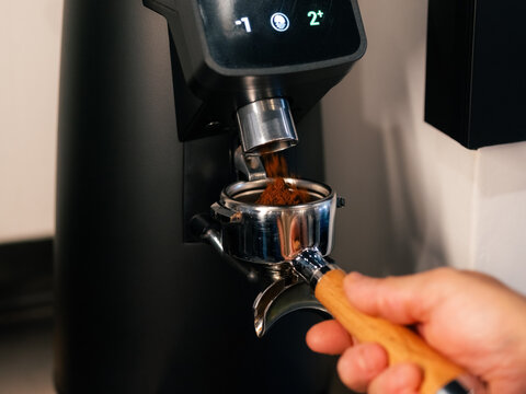 Barista grinding coffee into a portafilter 