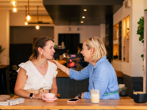 Excited women talking at cafe 