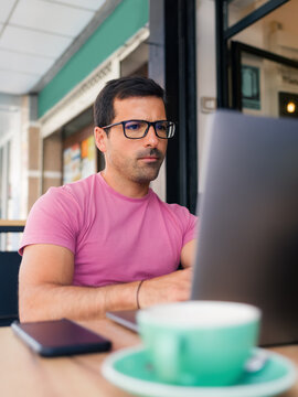 Focused man working at cafe using laptop 