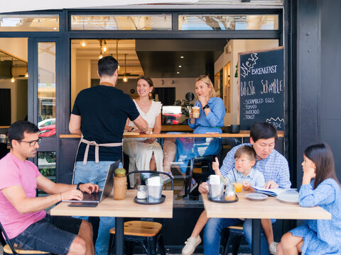 Barista serving his guests at cafe 
