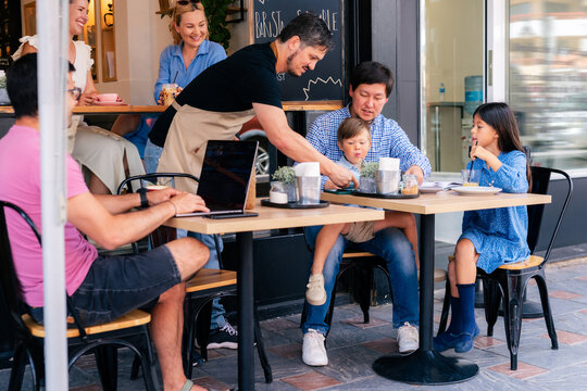 Focused waiter serving his guests at cafe 