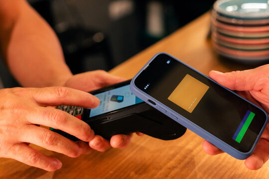 Person paying with smartphone at cafe 