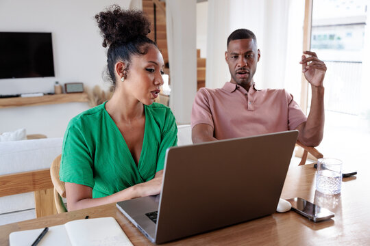 Couple working together on a laptop at home.