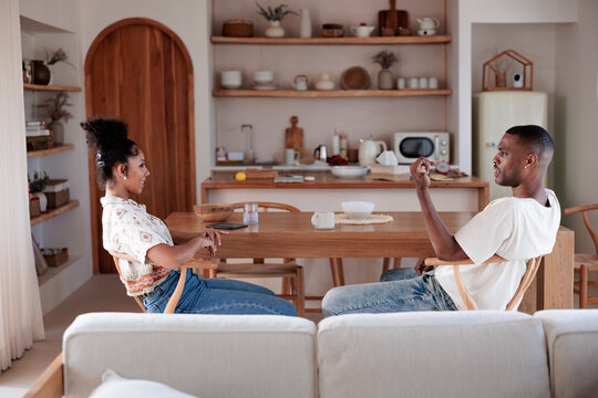 Couple conversing at kitchen table in bright, modern home.