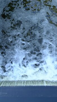 River water cascading over concrete spillway edge with foam