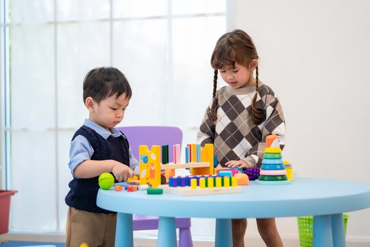 Children play with toys at a table in a light and bright room during the day