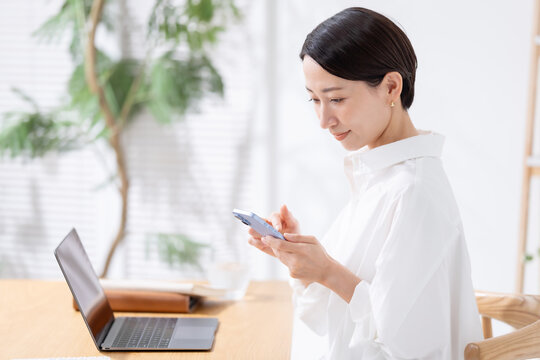 スマホとパソコンを使う女性