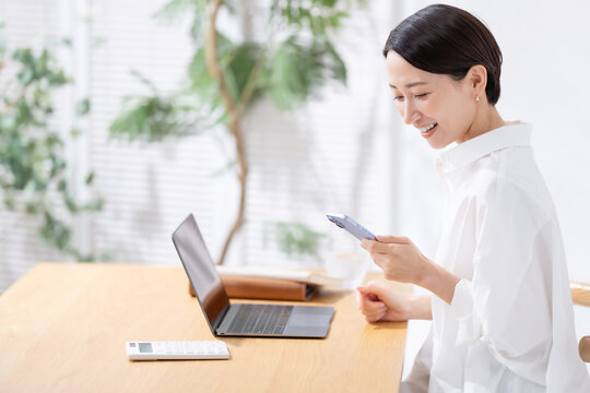 スマホとパソコンを使う女性