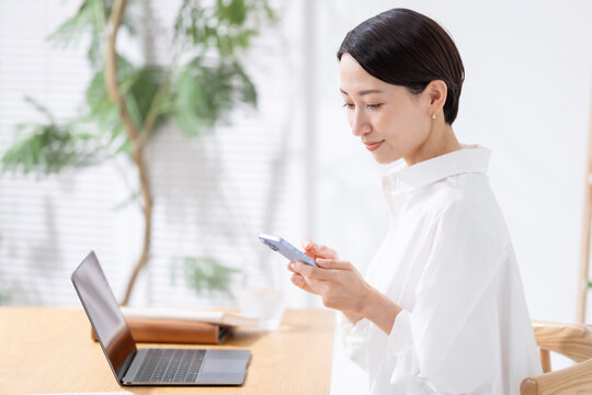 スマホとパソコンを使う女性