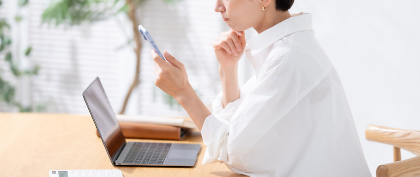 スマホを見て悩む女性