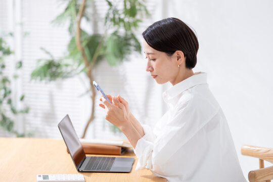 スマホを見て悩む女性